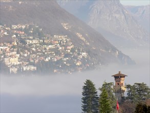 Alpine Village Lugano with a Tower over the Fog with Mountain in Ticino