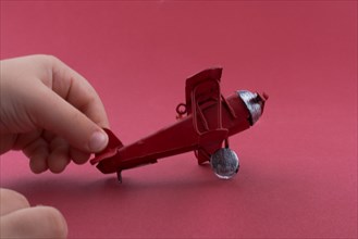 Child holding a little metal model airplane in hand
