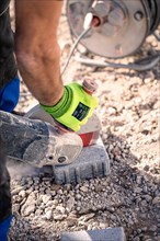 Man with glove laying natural stone floor on construction site