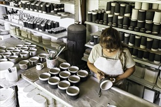 Working table of a ceramist. The process of creating pottery. The master ceramist works in her studio