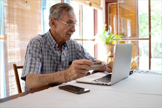 Mature man shopping online on laptop