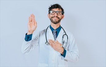 Doctor raising hand and swearing. handsome doctor making oath and promise isolated