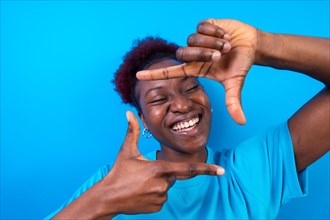 Young african american woman isolated on a blue background with gesture square from fingers