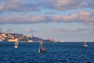 View of Lisbon over Tagus river from Almada with yachts tourist boats on sunset with dramatic sky. Lisbon