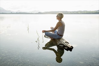 Woman sitting relaxed on a stone