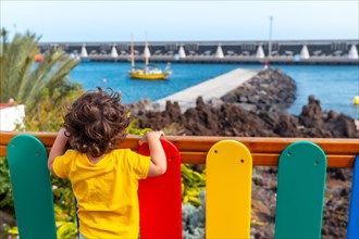 A child from a park looking at the port of La Restinga on El Hierro