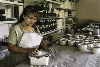 Ceramist working in pottery studio. Ceramists hands dirty clay. Process of creating pottery