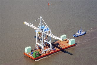 Tugboat with heavy load on a pontoon on the Elbe