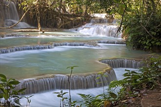Travertine cascades and turquoise blue pools of the Kuang Si Falls