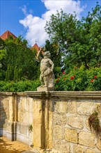Stone sculpture of a putto in the Abbey and Palace Garden of Quedlinburg