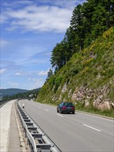 Typical traffic situation on the Bundesstrasse 500 with the Schluchsee to the left and gorse-covered rocks to the right