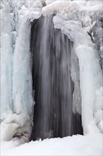 Frozen waterfall Kirkjufellsfoss on the Snaefellsnes peninsula in winter