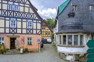 Listed historic buildings of the old town pharmacy and the former inn Am hohen Stein on the market square of Hohnstein