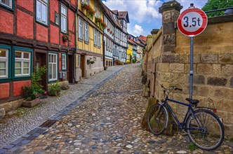 View through a narrow alley with historic heritage-protected half-timbered houses on the Schlossberg in the old town of Quedlinburg