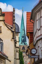 View through the narrow alley of Bockstrasse to one of the towers of the church St. Nikolai in the old town of the world heritage city