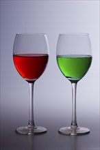 Two glasses of coloured colored drinks