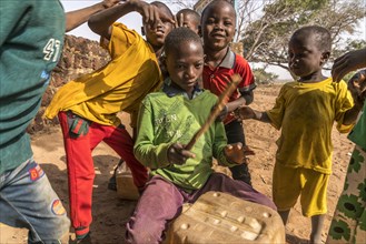 A group of African children with self-made drums singing and playing