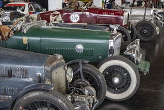 Historic racing cars lined up in a car park