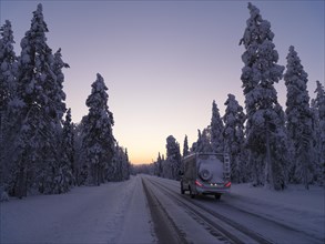 Travelling by motorhome in wintry Lapland at dawn