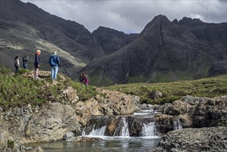 Black Cuillin and tourists visiting the Fairy Pools