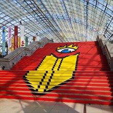 Book Fair logo on a staircase in the glass hall of the Leipzig Fair