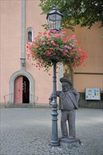 Sculpture on street lamp in front of church