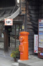 Post box in front of tobacconist at Narai-juku traditional small town in Nagano Japan