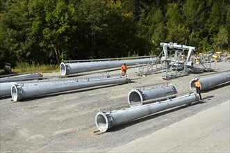 Tubular beams for the assembly of a ski lift lie on a construction site