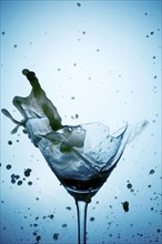 Powerful Splash breaking a martini glass