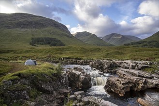 Wild camping with lightweight dome tent along the River Etive in Glen Etive near Glencoe in the Scottish Highlands
