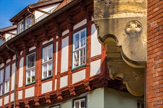 Upper facade detail of a richly decorated historic half-timbered house on the market square in the old town of Quedlinburg