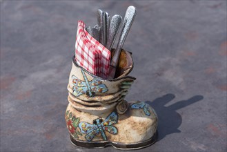 Ceramic boots as cutlery and napkin holder in a restaurant