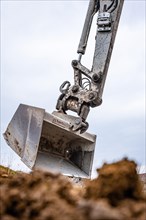 Excavator shovel with earth on construction site