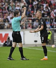 Referee Frank Willenborg shows Mitchel Bakker Bayer 04 Leverkusen