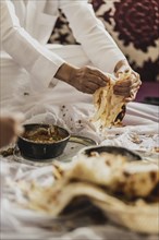 A man in traditional dress photographed with the Yemeni bread Malawach in Jeddah