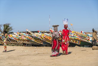 Women in front of the colourful fishing boats on the beach of Tanji