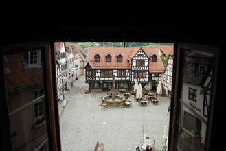 View through open window of the town hall on market place with half-timbered house