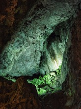 Illuminated walls coloured green by algae in limestone cave