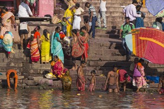 People take an early morning bath in the holy river Ganges