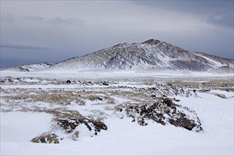 Stratovolcano Snaefellsjoekull and lava field covered in snow at the Snaefellsjoekull National Park in winter on the Snaefellsnes peninsula in Iceland