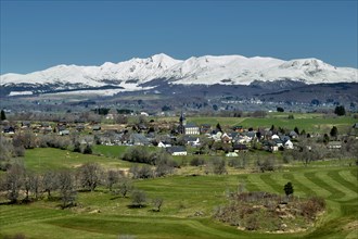 Regional natural park of the Volcanoes of Auvergne. View on the village of Saint Genes Champespe and the Monts Dore in winter. Puy de Dome department. Auvergne-Rhone-Alpes. France
