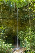 Waterfall at the limestone caves of Gruta da Judeia in the jungle