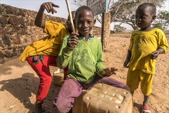 A group of African children with self-made drums singing and playing