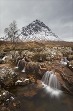 Scottish mountain Buachaille Etive Mor and waterfall on River Coupall in winter in Glen Etive near Glencoe in the Highlands of Scotland