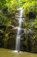 Man taking a bath under a small waterfall near the Zongo waterfall