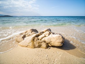 Rocks on the sandy beach near the campsite of Stara Baska