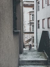 Passage between tenement houses with person on bike