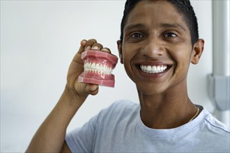 Young man smiles at the camera showing the result of orthodontic treatment