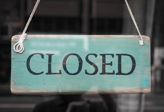 Closed sign in a shop showroom with reflections