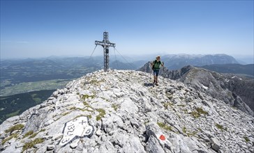 Mountaineer at the summit of the Hohe Brett with summit cross
